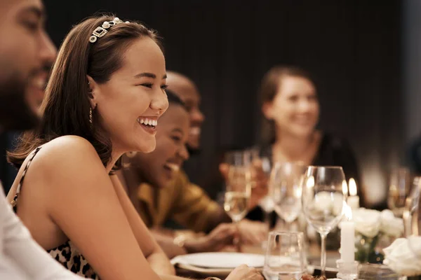 Je n'aurais pas pu demander une meilleure compagnie. Tourné d'une jolie jeune femme assise et profitant d'un dîner du Nouvel An avec des amis. — Photo