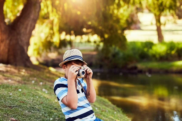 Ein paar malerische Aufnahmen im Park. Aufnahme eines kleinen Jungen beim Fotografieren mit einer Oldtimer-Kamera im Park. — Stockfoto