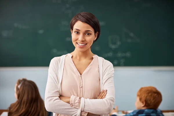 Es ist so ein erfüllender Beruf. Porträt einer jungen Lehrerin, die in einem Klassenzimmer steht. — Stockfoto