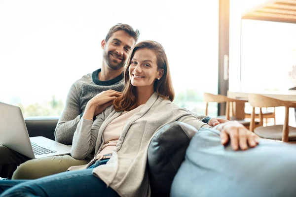 Grande compagnie est toujours rare à trouver. Portrait d'un jeune couple affectueux utilisant un ordinateur portable tout en se relaxant sur leur canapé à la maison. — Photo