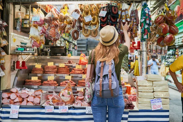 너무 많은 선택들 이요. 진열 된 물품들을 둘러보면서 시장 옆에 서 있는 알아볼 수없는 한 여자의 사진 이전 시되어 있다. — 스톡 사진