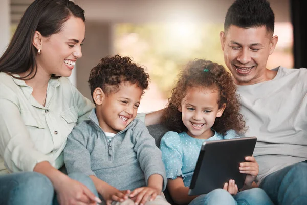 Uwielbiamy ten program. Zdjęcie młodej rodziny korzystającej z tabletu cyfrowego w domu. — Zdjęcie stockowe
