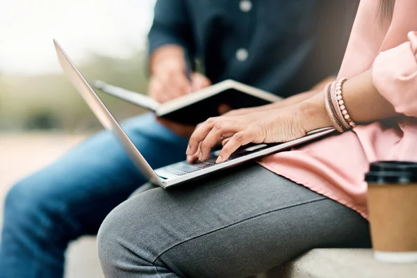 Streef niet naar succes, maar naar waarde. Foto van twee onherkenbare studenten die een laptop gebruiken terwijl ze buiten op de campus zitten. — Stockfoto