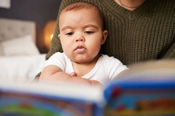 De todas las cosas que sostuve, mi niño es el más hermoso y precioso. Le disparó a una madre leyendo un libro a su bebé en casa.. — Foto de Stock