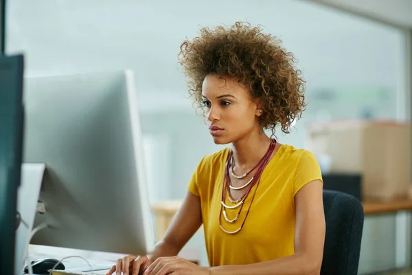 Sie bringt bei jeder Aufgabe einen einzigartigen Fokus mit. Aufnahme einer Geschäftsfrau, die im Büro an ihrem Computer arbeitet. — Stockfoto
