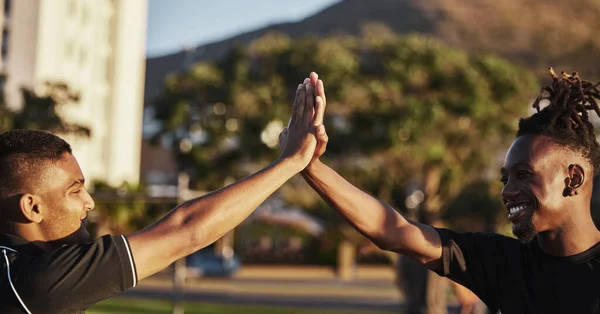 Trainen met een vriend voor ondersteuning. Opname van twee mannelijke vrienden die trainen bij zonsondergang. — Stockfoto