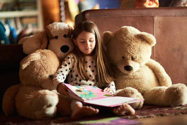 彼女を読むと物語になる。彼女の周りに彼女のテディベアと一緒に本を読んで女の子のショット. — ストック写真