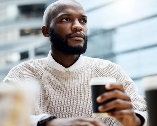 Koffie roert alle ambitieuze gedachten. Schot van een jonge zakenman die er attent uitziet terwijl hij koffie drinkt buiten een kantoor.. — Stockfoto