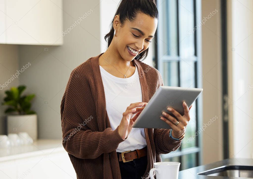 Lets see if my favourite store has any new arrivals. Shot of a young woman using a digital tablet at home.
