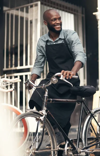 Я найкращий продавець велосипедів у містах. Постріл красивого молодого чоловіка, що рухає велосипед зі свого магазину протягом дня . — стокове фото