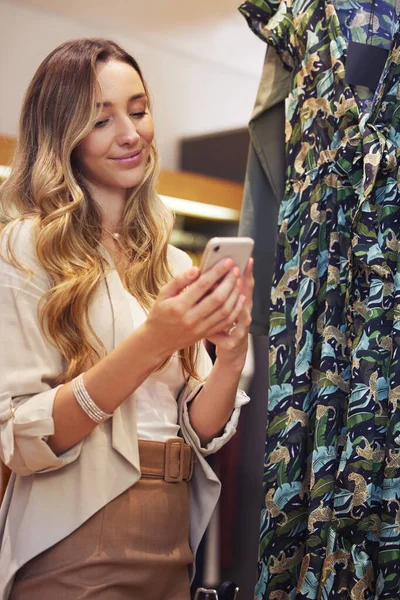 Süße Texte bringen mich immer zum Lächeln. Aufnahme einer jungen Frau beim Einkaufen mit ihrem Smartphone. — Stockfoto