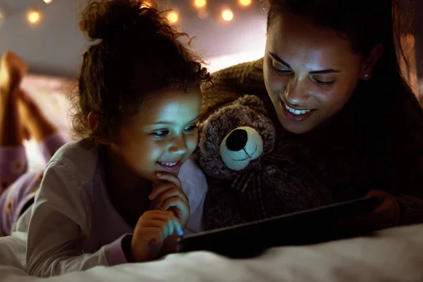 Kunnen we naar mijn show kijken? Foto van een moeder en dochter met behulp van een digitale tablet voor het slapen gaan. — Stockfoto