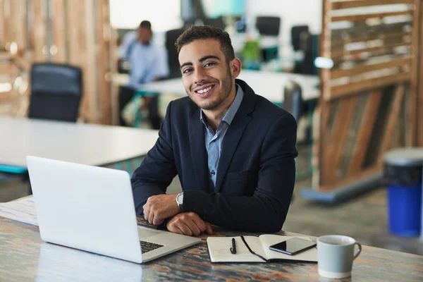 Det kommer att bli ännu en produktiv dag. Porträtt av en ung affärsman som arbetar på en bärbar dator på ett kontor. — Stockfoto