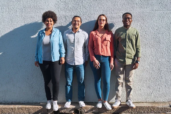 Todos tenemos un lugar en nuestra comunidad. Fotografía de un grupo de jóvenes de pie juntos sobre un fondo urbano al aire libre. — Foto de Stock