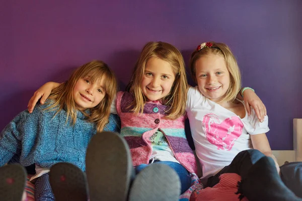 Felicità infantile. Ritratto di un gruppo di bambine sedute insieme su uno sfondo viola. — Foto Stock