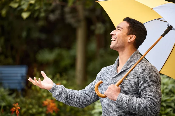 Cuando llueve, llueve. Un disparo de un joven de pie bajo la lluvia con un paraguas. — Foto de Stock