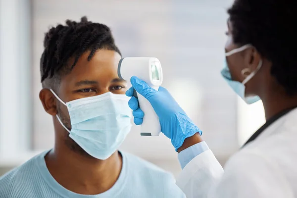 Tu temperatura parece un poco alta. Inyección de una doctora tomando la temperatura de su paciente. — Foto de Stock