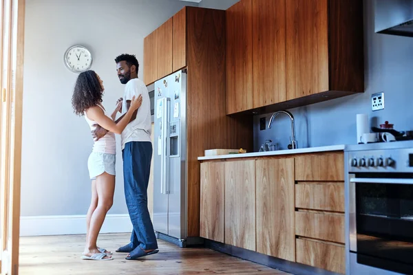 Dans med meg. Et bilde av et kjærlig ungt par som danser på kjøkkenet sitt hjemme.. – stockfoto