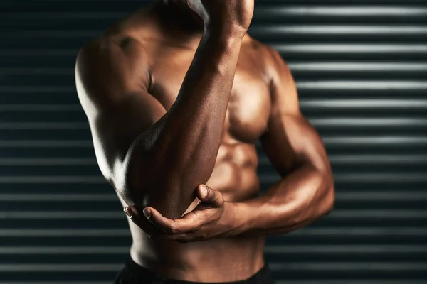 锻炼关节周围的肌肉。一名无法辨认的男子在锻炼过程中检查肘部受伤的摄影棚照片. — 图库照片