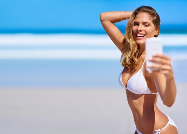 Świętowanie lata z seksownym selfie. Strzał atrakcyjnej młodej kobiety cieszącej się wakacjami na plaży. — Zdjęcie stockowe