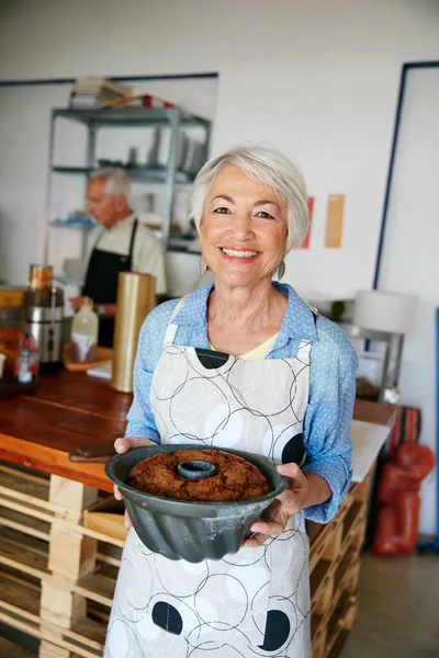 Horneado por los mejores en el negocio. Fotografía de una mujer mayor trabajando en una panadería. — Foto de Stock
