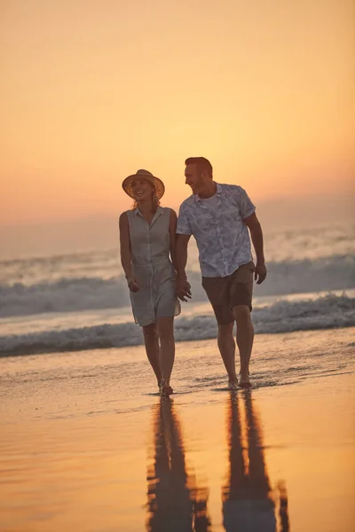 Tu me donnes envie de faire ces choses stupides par amour. Tourné d'un couple d'âge mûr affectueux faisant une promenade sur la plage. — Photo