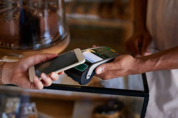 Se han ido los días de llevar dinero encima. Primer plano de un cliente que paga con tecnología NFC en la cafetería. — Foto de Stock