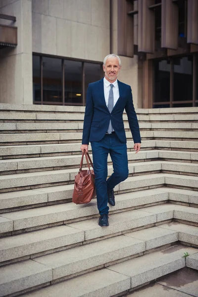 Ir para casa depois de um dia produtivo. Retrato de um empresário confiante deixando seu prédio de escritórios depois de um dia no trabalho. — Fotografia de Stock