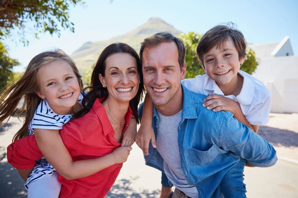 Familie maakt het leven de moeite waard. Portret van een gelukkig gezin met jonge kinderen die samen poseren buiten hun huis. — Stockfoto