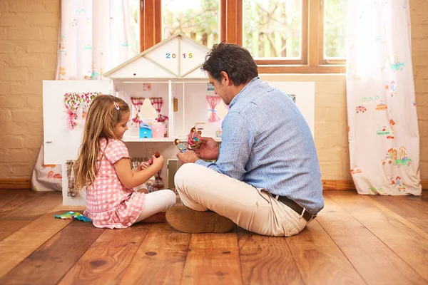 Transformando o tempo de jogo em tempo de qualidade. Tiro de um pai e filha brincando juntos com uma casa de bonecas em casa. — Fotografia de Stock