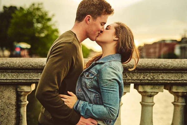 Βρήκαμε ένα ιδιαίτερο είδος αγάπης. Τραβηγμένο πλάνο ενός αγαπημένου νεαρού ζευγαριού να μοιράζεται ένα φιλί ενώ είναι έξω σε ραντεβού. — Φωτογραφία Αρχείου