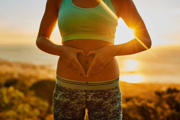 She loves her body. Shot of an unrecognizable young woman making a heart with her hands on her stomach. — Stock Photo, Image
