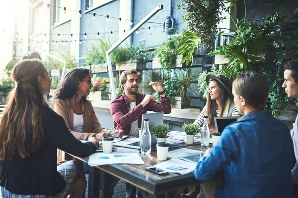 Travailler en dehors des sentiers battus. Prise de vue d'un groupe de designers en réunion dans un café. — Photo