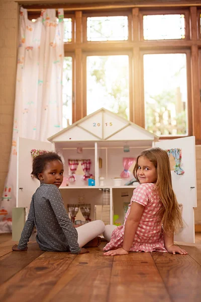 Theres nothing better than best friends playing together. Portrait of two friends playing together with a dollhouse. — Stock Photo, Image