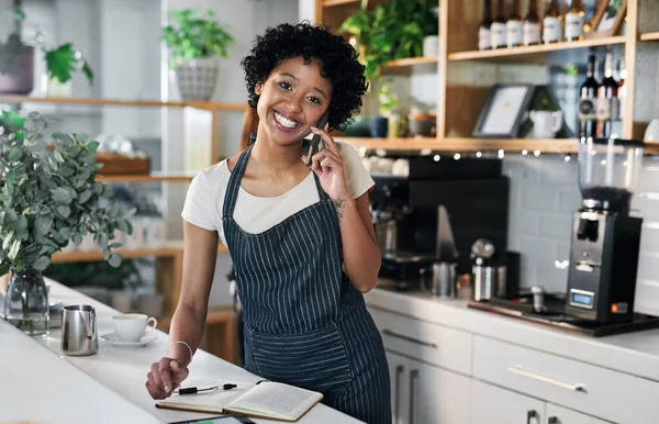 Commander un peu plus d'actions auprès de ses fournisseurs de confiance. Portrait d'une jeune femme parlant sur un téléphone portable alors qu'elle travaillait dans un café. — Photo
