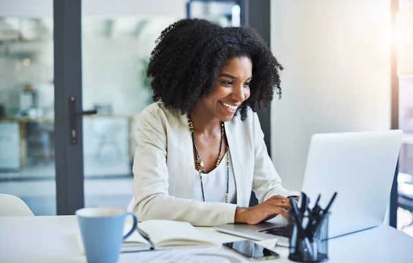 Envía rápidamente las buenas noticias al equipo. Fotografía de una joven empresaria trabajando y de buen humor en el escritorio de su oficina. — Foto de Stock