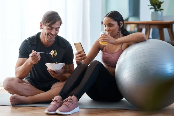 간식을 다 먹고 나 서요. 운동 선수인 젊은 부부 가집에서 운동을 한 후 건강에 좋은 간식을 먹고 있는 모습 이장기적으로 찍은 사진. — 스톡 사진