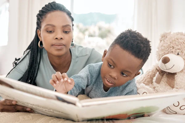 Leyendo con mamá. Recortado disparo de un niño adorable y su madre leyendo un libro en una cama en casa. — Foto de Stock