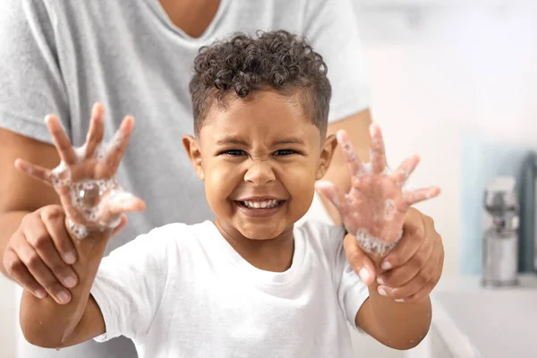 Mamma sa att baciller är dåliga. Skjuten av en bedårande liten pojke som står i badrummet och tvättar händerna medan hans mamma hjälper honom. — Stockfoto