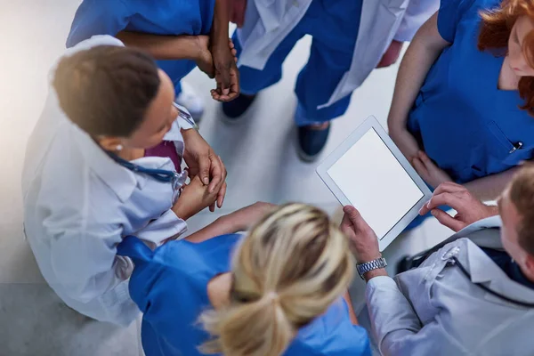 Rimanere in cima alle ultime scoperte mediche. Colpo ad angolo alto di un team di medici che utilizzano un tablet digitale insieme. — Foto Stock