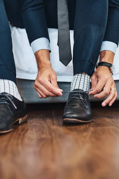 Manteniendo apretado su juego de zapatos. Cortada la foto de un hombre irreconocible atándose los cordones en su dormitorio en casa. — Foto de Stock