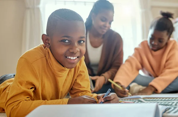 Adoro não ter de ir à escola. Tiro de um menino completando sua lição de casa, enquanto sua mãe ajuda ele e sua irmã. — Fotografia de Stock