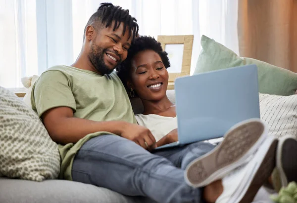 Du bon temps ensemble. Prise de vue d'un jeune couple à l'aide d'un ordinateur portable assis sur le canapé à la maison. — Photo