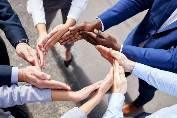 Uno con el movimiento del éxito. Shot de un grupo de empresarios irreconocibles formando un círculo con las manos fuera. —  Fotos de Stock