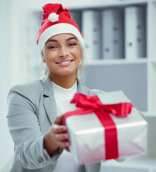 I saw this and thought of you. Portrait of a young beautiful woman spreading Christmas cheer with gifts at the office.