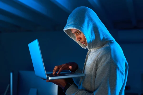 Maak je klaar om je persoonlijke gegevens met de wereld te delen. Foto van een jonge mannelijke hacker met behulp van een laptop in het donker. — Stockfoto