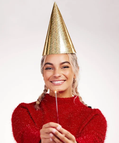 La Navidad es hacer algo extra por alguien. Foto de estudio de una mujer joven con un sombrero de fiesta mientras sostiene un bengala sobre un fondo gris. — Foto de Stock