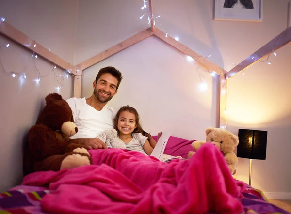 É uma rotina para dormir sem uma história para adormecer. Retrato de um pai lendo um livro com sua filha na cama em casa. — Fotografia de Stock