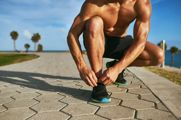 A preparar-se para o seu melhor desempenho. close-up tiro de um homem irreconhecível amarrando seus atacadores durante o exercício ao ar livre. — Fotografia de Stock