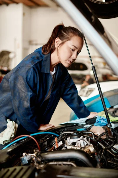É o meu trabalho resolver problemas desafiadores. Tiro de uma mecânica feminina trabalhando em um carro em uma oficina de reparação de automóveis. — Fotografia de Stock
